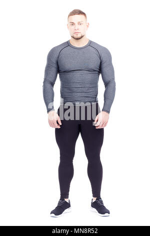 Portrait von Stattlichen gut bemuskelt gym Instructor im Sport Strumpfhosen und rashguard auf weißem Hintergrund posiert Stockfoto