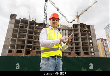 Portrait von lächelnden Mann Architekt mit digitalen Tablet auf der Baustelle Stockfoto