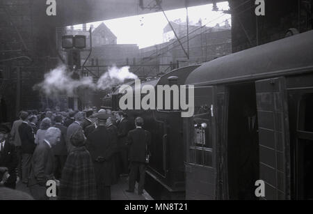 1960, historische Bild zeigt eine Gruppe von Menschen, die darauf warteten, von einer Dampflok draußen auf einer Plattform an Liverpool Lime Street Station, England Großbritannien. Stockfoto