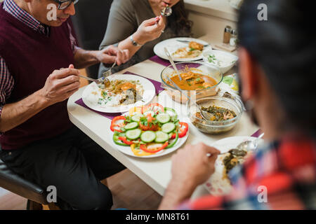 Nahaufnahme von hausgemachten indisches Essen auf einer Familie Esstisch. Sie essen Curry mit Salat. Stockfoto