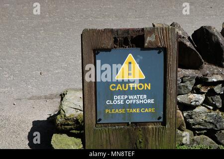 'Achtung tiefes Wasser in der Nähe Offshore Bitte achten Sie 'gelben und grauen Schild am Ufer des Loch Ness in Schottland, Großbritannien. Stockfoto