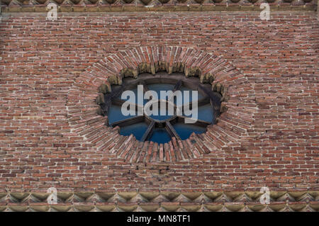 Rosette aus Holz und Glas in einem Backstein Fassade einer Kirche in Madrid. Spanien Stockfoto