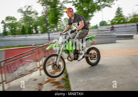Einen weißen Mann reitet ein Motorrad die Treppe runter in einem Park. Stockfoto