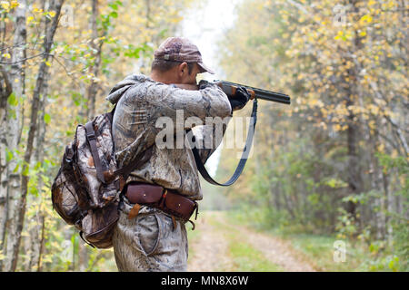 Hunter in der Tarnung Ziel aus einer Schrotflinte in der wildvogel Stockfoto