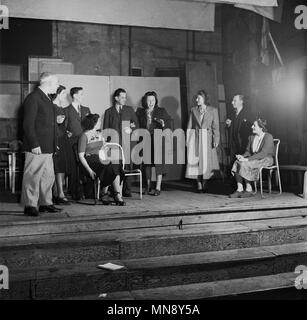 1950, historische, amateur Dramatik, meine Damen und Herren, die auf eine alte hölzerne Bühne während der Proben von einem Spiel, England, UK. In dieser Ära, amateur Theater war beliebt und Proben würde in allen Schauplätzen einschließlich Kirche hallen und die örtlichen Sportvereine statt. Stockfoto