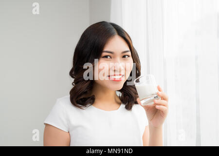 Glückliche junge Frau Trinkmilch Stockfoto