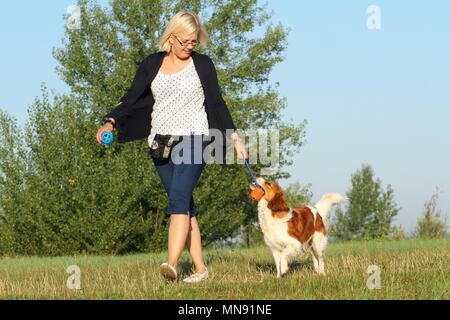 Frau und Kooikerhondje Stockfoto