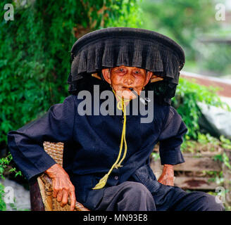 Hong Kong, China; Hakka Frau traditionellen Hut raucht eine Pfeife Stockfoto