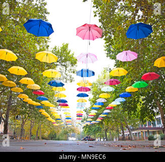 Viele bunte Schirme hängen auf der Straße Stockfoto