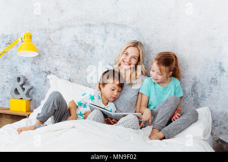 Schöne Mutter ist lesen eine Geschichte für ihre Kinder Stockfoto