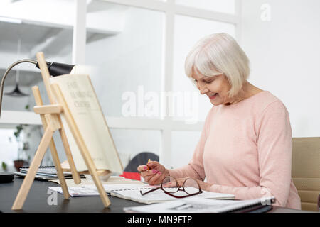 Ältere Frau die Arbeit an Aufgabe zufrieden Stockfoto