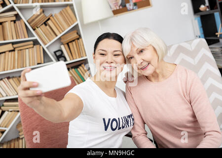 Freudige freiwillige und älterer Frau unter selfie Stockfoto