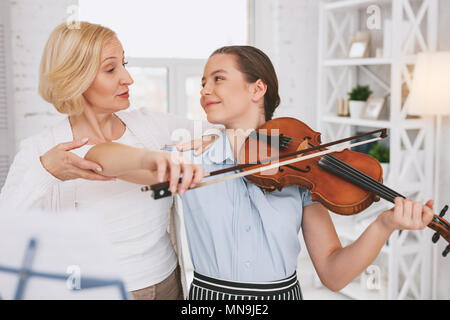 Aufmerksame Frau ihre Schüler helfen Stockfoto