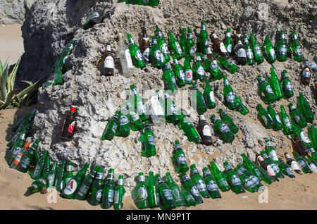 Der Strand von Tsampika, Insel Rhodos, Griechenland - 21. September 2017: wunderschön angelegten leeren Bierflaschen auf einem riesigen Felsblock in einem sonnigen Wetter. Marke Stockfoto