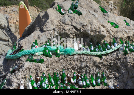 Der Strand von Tsampika, Insel Rhodos, Griechenland - 21. September 2017: wunderschön angelegten leeren Bierflaschen auf einem riesigen Felsblock in einem sonnigen Wetter. Marke Stockfoto