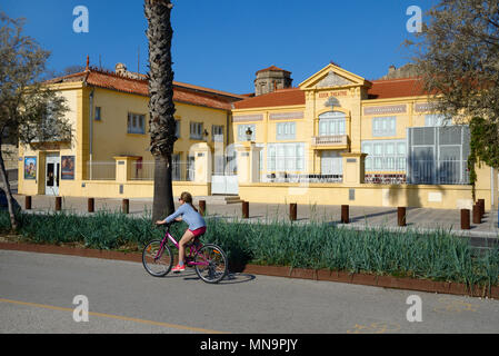 Mädchen Radfahren in Radweg vorbei an der historischen Eden Theater oder Eden Theater, eine der frühesten Kino der Welt oder Kino, La Ciotat, Frankreich Stockfoto