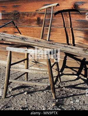 Alte, verwitterte und ausrangierten Holzstuhl steht außerhalb einer verfallenen und verlassenen Wüste und bietet hohen Desert Homestead in der Mojave, Kalifornien, USA. Stockfoto