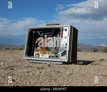 Ein alter Fernseher, Fernseher, kaputt und kein Bildschirm, sitzt auf dem Sand der Wüste, die Mojave, in Wonder Valley, in der Nähe von Joshua Tree, Kalifornien, USA Stockfoto