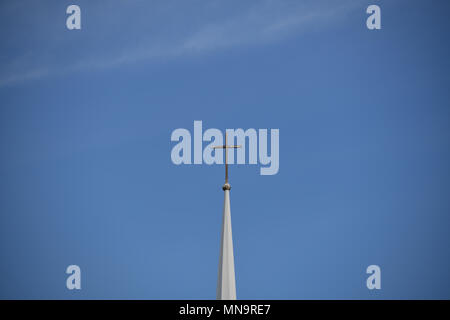 "Der Turm" der amerikanischen Serie 'ein Kreuz sitzt hoch oben auf einem traditionellen Kirchturm vor dem Hintergrund eines klaren blauen Himmel Stockfoto