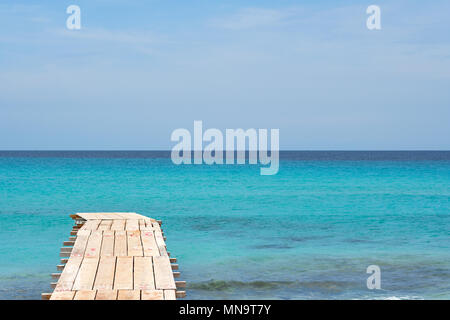 Holzsteg und türkisblauem Wasser am Illetas Strand in Formentera. Balearen. Spanien Stockfoto