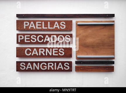 Restaurant Menü in spanischer Sprache auf eine weiße Wand. Inschriften der Lebensmittel- und Getränkeindustrie. Paella, Fisch, Fleisch und Sangria. Stockfoto