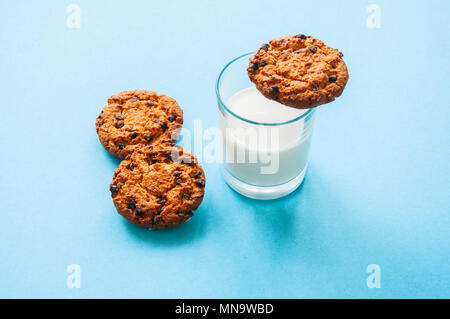 Chocolate Chip Cookies mit einem Glas Milch auf einem hellblauen Hintergrund. Stockfoto