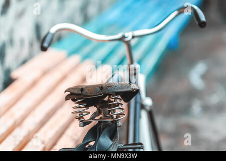 Ein altes Fahrrad mit einer Feder Stoßdämpfer. Vintage Fahrrad auf der Steinmauer Hintergrund. Stockfoto