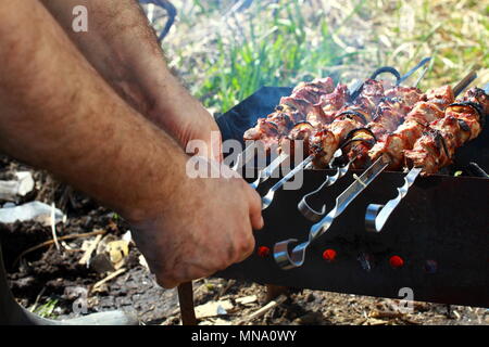 Ein Mann bereitet sich auf dem Grill lecker Grill. Stockfoto