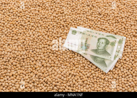 Uns China Sojabohne Tarife Konzept - Chinesische Renminbi Banknote mit Massen von Raw/chemische Sojabohnen. Uns China Handelskrieg Konzept, China soybean Tarife. Stockfoto