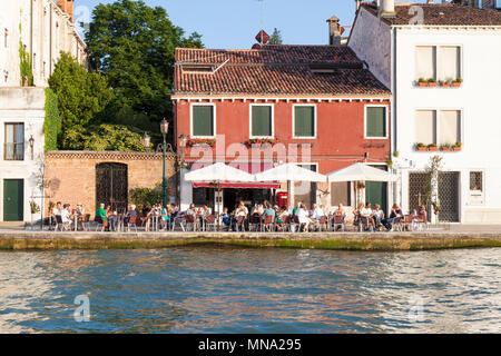 Die Menschen genießen einen Sundowner (Getränke) außerhalb der Bar da Matteo auf der Fondamenta Zitelle, Canale della Giudecca, Giudecca, Venedig, Venetien, Italien bei Sonnenuntergang Stockfoto