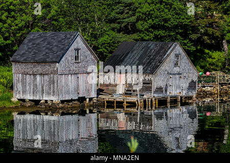 Alte angeln Schuppen im Wasser an der Küste von Nova Scotia, Kanada widerspiegelt. Stockfoto