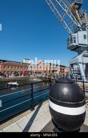 Eine alte Versand werft Kran und einen Weltkrieg zwei Mine auf dem Kai oder hafenmauer Wasserseite an Gunwharf Quays in Portsmouth, Hampshire, uk. Krane. Stockfoto