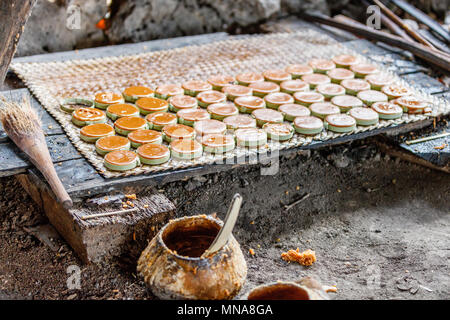 Traditionelle Verfahren der Palm Zucker in das Dorf in der Rote Insel, Indonesien. Dicke 'Toddy' (verdampft Palm sap) in Bambus Ringe gegossen. Stockfoto