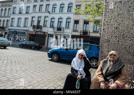 Die älteren muslimischen Frauen Rest an einem heißen Tag neben dem molenbeek Markt. Molenbeek ist einer der 19 Bezirke, die bis Brüssel, die Hauptstadt von Belgien. In der jüngsten Geschichte Molenbeek ist berüchtigt dafür, dass das Herz des islamischen Extremismus in Europa geworden. Pro Kopf der Bevölkerung, Molenbeek hat die größte Anzahl der radikalen Islamisten in Europa nach Syrien gereist mit ISIS zu kämpfen. Stockfoto