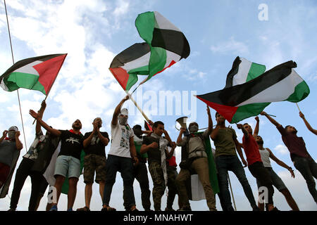 Athen, Griechenland. 15 Mai, 2018. Palästinensische Demonstranten wave Flags während einer Demonstration Solidarität mit dem palästinensischen Volk nach dem Tod von palästinensischen Demonstranten im Gazastreifen zum Ausdruck zu bringen, die ausserhalb der Israelischen Botschaft in Athen, Griechenland, 15. Mai 2018. Credit: Marios Lolos/Xinhua/Alamy leben Nachrichten Stockfoto