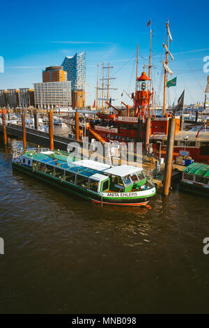 Hamburg, Deutschland - 17. Mai 2018: HafenCity, Speicherstadt: Panoramablick von Red Fire patrol Boot mit einem Restaurant auf der Platine. Die moderne Elbphilharmonie Gebäude im Hintergrund Stockfoto