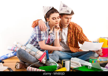 Reparieren Sie Familie durch das glückliche Paar Gebäude Haus mit weißen Laptop. Stockfoto