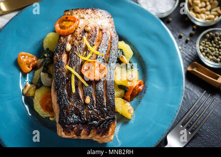 Frisch gegrillter Lachs mit Gemüse auf blauen Platte. Gesunde Mahlzeit Konzept. Stockfoto