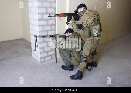 Die Aufständischen mit AK47 und Pistole im Gebäude Stockfoto
