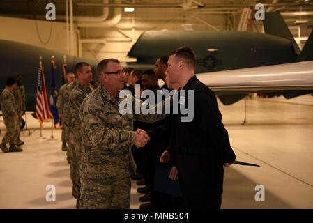 Staff Sgt. Cameron Johnson, ein Betreuer mit der 69Th maintenance Squadron, rechts, nimmt Glückwünsche von Maj. Christopher Seamans, 69 MXS Commander, nachdem er und eine Gruppe von Piloten mit 69 MXS als engagierte Mannschaft Leiter für die RQ-4 Global Hawks in einer Zeremonie Februar 23, 2018, Grand Forks Air Force Base, N.D. ausgewählt wurden. Die engagierte Mannschaft Leiter sind jeweils verantwortlich für eine Maschine, die ihren Namen auf. (U.S. Air Force Stockfoto