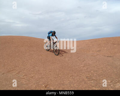 Biker Riding Downhill der berühmten Slickrock Trail, Moab, USA Stockfoto