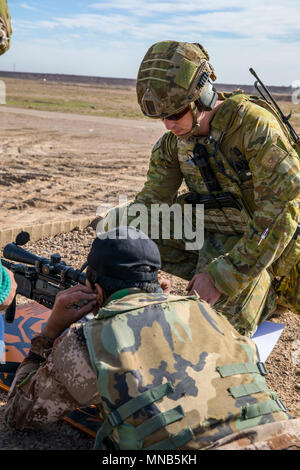 Australische Armee Cpl. Lukas Ryder, mit Task Force Taji, unterstützt ein irakischer Soldat 74th Brigade zugeordnet, mit Sehenswürdigkeiten passt auf eine M40-Schraube - Action Sniper Rifle während der nullabgleich Teil der erweiterten Treffsicherheit Training im Camp Taji, Irak, 18. März 2018. Camp Taji ist ein Combined Joint Task Force - inhärenten Lösen erweiterte Partner Lage zu Training Partner Kräfte und Verstärkung ihrer Wirksamkeit gewidmet. (U.S. Armee Stockfoto