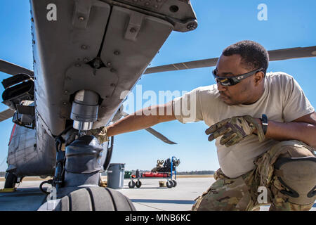 Senior Airman Latrell Salomo, 41. Rescue Squadron (RQS) spezielle Missionen aviator, inspiziert das Fahrwerk eines HH-60G Pave Hawk, 15. März 2018, bei Moody Air Force Base, Ga Flieger vom 41. RQS und 723 d Aircraft Maintenance Squadron durchgeführt vor, um zu gewährleisten, dass ein HH-60G Pave Hawk war voll für eine simulierte Suche und Rettung Mission vorbereitet. (U.S. Air Force Stockfoto