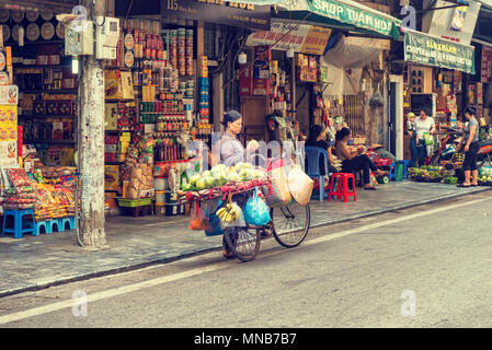 Hanoi, Vietnam - 27. Oktober 2017: Straßenhändler in Hanoi, Vietnam verkauft Früchte von seinem Fahrrad. Stockfoto