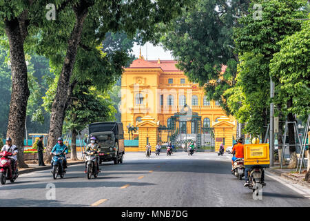 Hanoi, Vietnam - 27. Oktober 2017: Leute, Motorradfahren auf der Straße vor dem Eingang zum Präsidentenpalast von Vietnam in Hanoi. Stockfoto