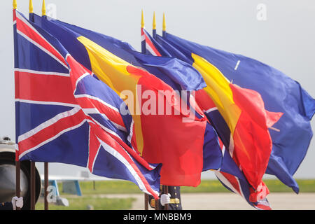 Die NATO, Großbritannien und Rumänien Fahnen schwenkten im Wind Stockfoto