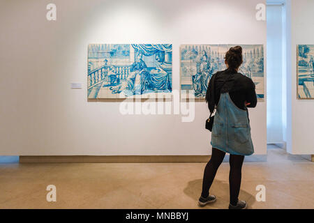 Portugal Fliesenmuseum, eine Frau sieht ein Paar Porträts aus dem 18. Jahrhundert auf blauen Kachelplatten - oder Tapeten - im Museu Nacional do Azulejo, Lissabon. Stockfoto