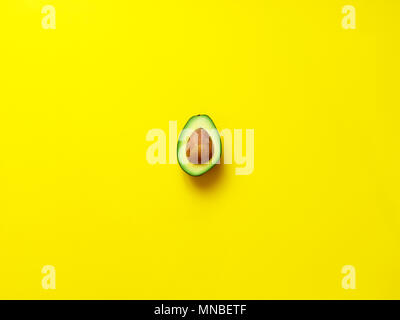 Avocado mit Samen auf gelben Hintergrund isoliert von oben betrachtet - flatlay suchen Stockfoto