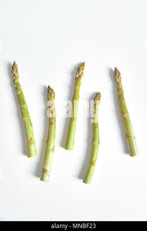 Nahaufnahme von fünf Spargel Zweige liegen auf weißem Hintergrund. Stockfoto