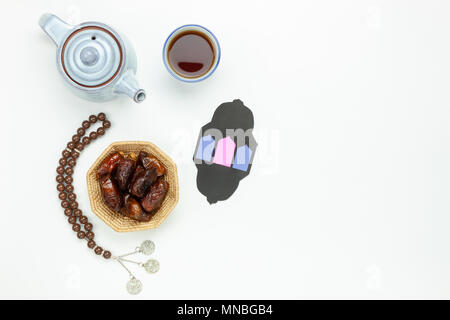 Tabelle Ansicht von oben Luftbild der Dekoration Ramadan Kareem urlaub Hintergrund. Flach Datum in Holz Korb mit weiß Rosenkranz & grüner Tee. halal Essen einstellen Stockfoto